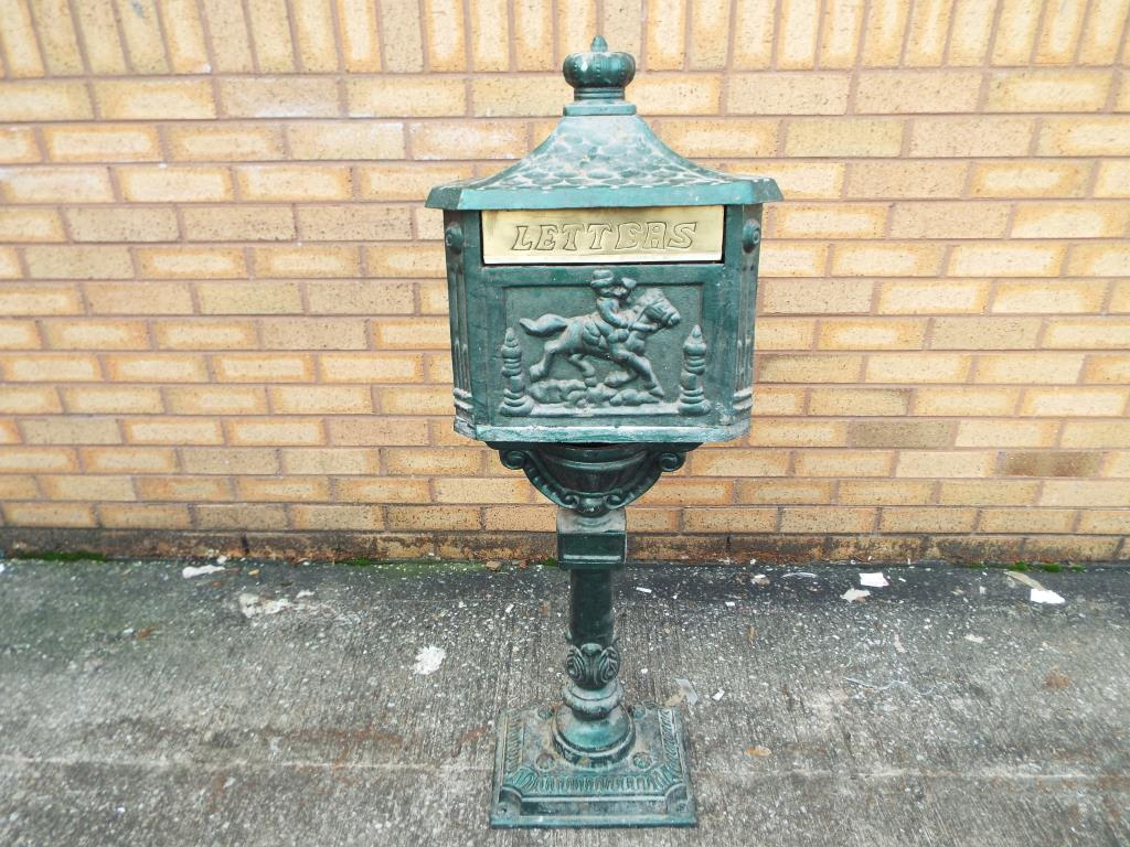 A cast iron letter box with stand, approximate height 120 cm, [in two pieces for transportation].