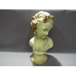 A plaster bust of a young lady with grapes and leaves in her hair,