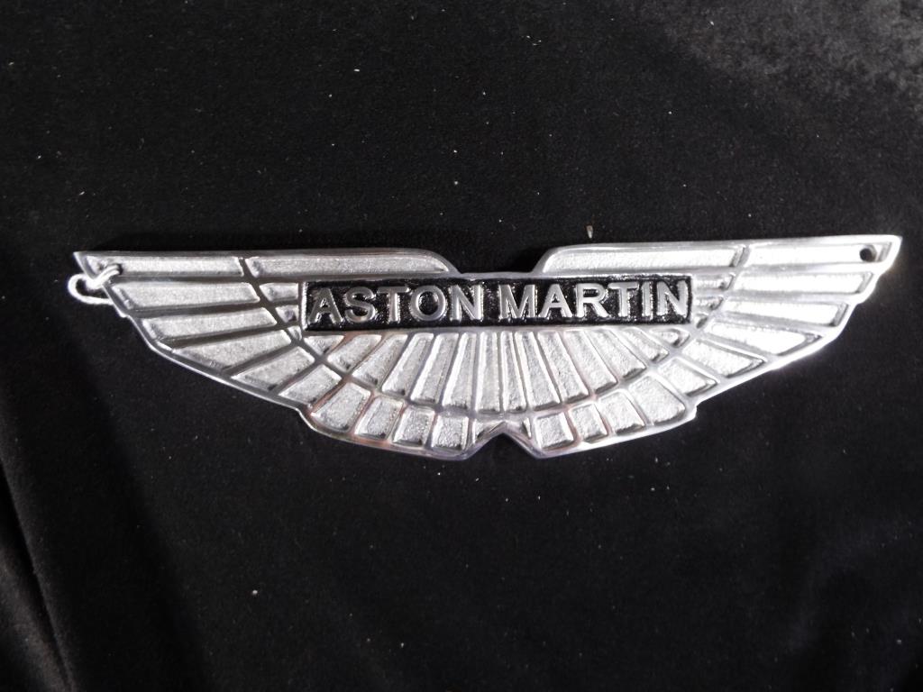 A white metal wall plaque scribed 'Aston Martin', 29.