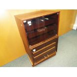 Two La Rosita storage music cabinets with glass fronted doors containing three pullout shelves per