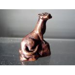 A diminutive hot cast bronze in the form of an otter seated on rocks.