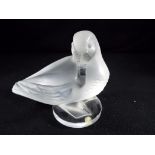 Lalique - a frosted glass model depicting a duck on circular base, signed, approximately 11 cm [H].