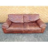 A three seater brown leather sofa,
