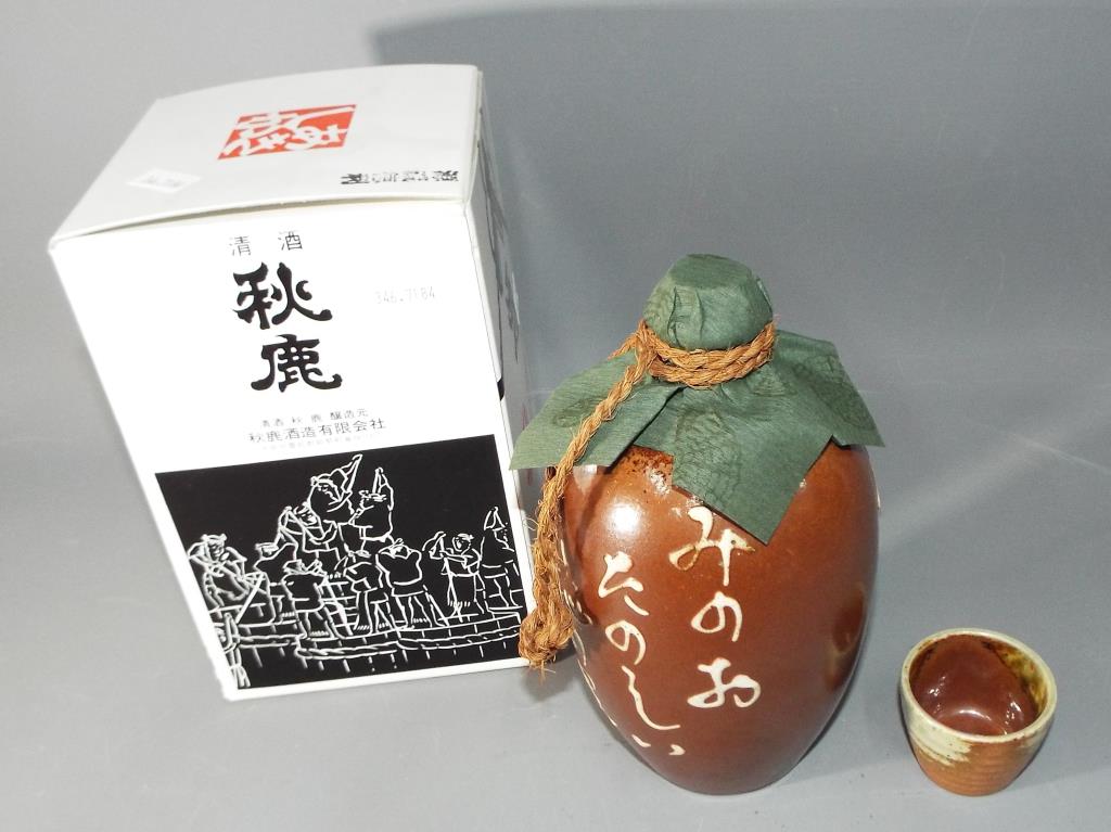 A boxed Oriental stoneware jug, sealed with content and supplied with small cup.