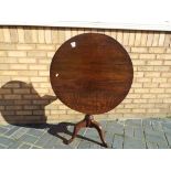 A vintage oak tilt top occasional table approximately 70 cm high and 72 cm diameter.