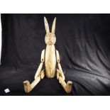 A large wooden articulated Rabbit for shelf display, approx 50 cm (seated),