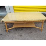 A Lloyd Loom coffee table with glass top,