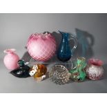 A collection of mixed glassware to include paperweights, vases and similar.