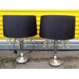 Two modern chrome table lamps each having four arms holding a candle bulb with four drop crystal