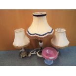Three various sized table lamps set on hard stone columns and a glass centrepiece [4].