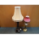 A brass and glass oil lamp with glass shade and funnel and a pillar standard lamp with neutral