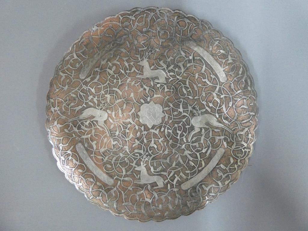 A Cairoware copper and silver inlaid plate with deer and scrolling foliate decoration,