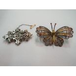 A large silver and yellow metal brooch in a form of a butterfly,