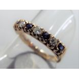 A hallmarked 9 carat gold half eternity ring set with seven stones comprising four sapphires and