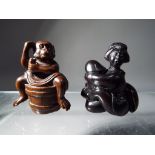 Netsuke - two vintage dark wood Japanese netsukes one in a form of a monkey sitting on a barrel,