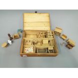 A wooden case containing a quantity of doll's house furniture circa 1930s to include bedroom sets,