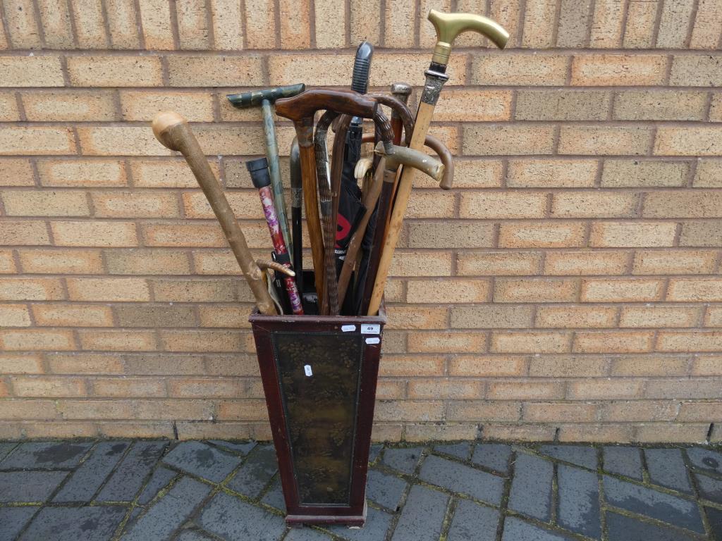 A walking stick holder with a quantity of walking sticks and similar,