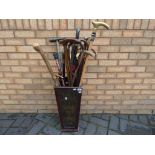 A walking stick holder with a quantity of walking sticks and similar,
