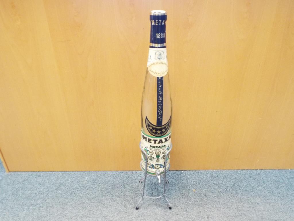 A very large Metaxa bottle on stand, approximately 80 cm (h) including stand.