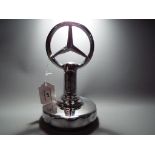 A chrome Mercedes sign,