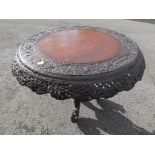 A highly carved tilt top table,
