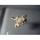 An articulated frog costume brooch