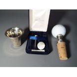 A silver hallmarked golf tee and marker in presentation case,
