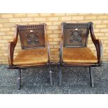 Two highly carved oak arm chairs with leather removable cushions.
