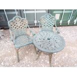 A cast iron garden patio set comprising a table and two armchairs,