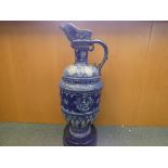 A very large Gres De Flandres stoneware ewer approximately 85 cm [h] with wooden stand and plague