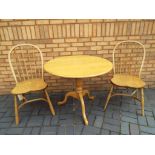 A pine flip top breakfast table with two pine chairs,