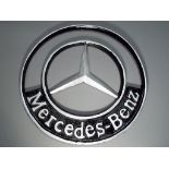 A modern cast Mercedes Benz sign