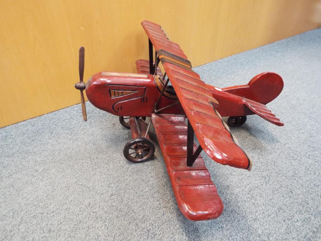 A wooden model of biplane approximately 35 cm x 68 cm x 77 cm.