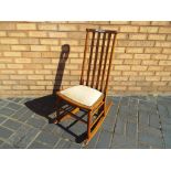 An oak rocking chair with upholstered seat