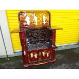 An Oriental lacquered drinks cabinet featuring Geisha girls,