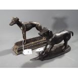 Two cast figurines depicting Retriever and Greyhound set on the plinth,