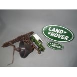 A cast iron wall hanging bell and two cast iron advertising wall plaques marked Land Rover [XLR3]