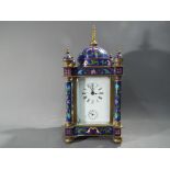 A small Eastern style desk or mantel clock, white enamel dial with Roman numerals, signed M.D.