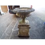 A large reconstituted stone planter on plinth.