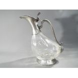 A white metal and glass decanter in the form of a bird,