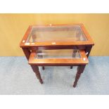 A glass topped nest of two tables, largest approximately 54 cm x 56 cm x 36 cm.