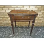 An oak sewing table with electric Singer sewing machine fitted and a selection of accessories in