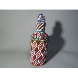 A vintage blue glass bottle with bead work bottle cover in a geometric pattern approx 16cm (h)
