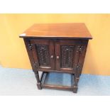 A small utility two door cupboard with carved detailing to the front,