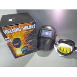 A welding helmet - an auto darkening welding helmet (MASK2), unused in original box.