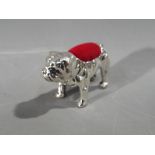 A silver pin cushion in the shape of a bulldog