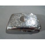 A George V silver hallmarked cigarette case with chased decoration, Birmingham assay 1922,