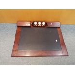 A wooden desk top with inset writing surface, integral pen tray and world time clocks,