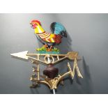 A cast iron weather vane depicting a hand painted cockerel,
