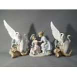 Nao - three Nao figurines a pair depicting storks and a figural group depicting two young girls,